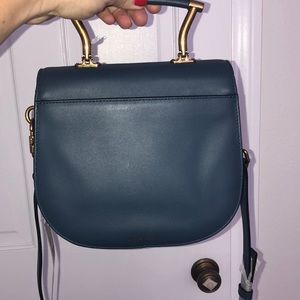 Blue leather saddlebag with gold hardware.